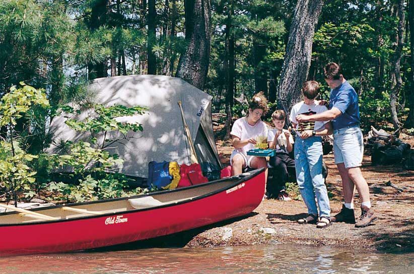 A family with a tent and canoe by the lake