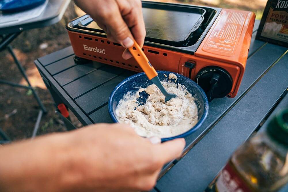 Stiring up an instant breakfast meal in a bowl on the Eureka! Camp Kitchen table with a Jetboil JetSet utensil