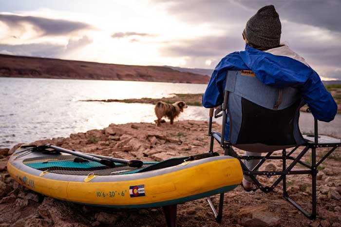 Camper with paddle board and dog watching the sunset at Lake Powell