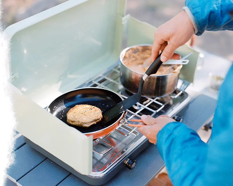 A close up photo of a green Eureka Ignite camp stove.