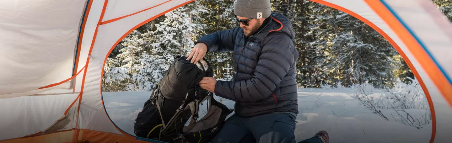 Man packing up from a Eureka Mountain Pass backpacking tent.